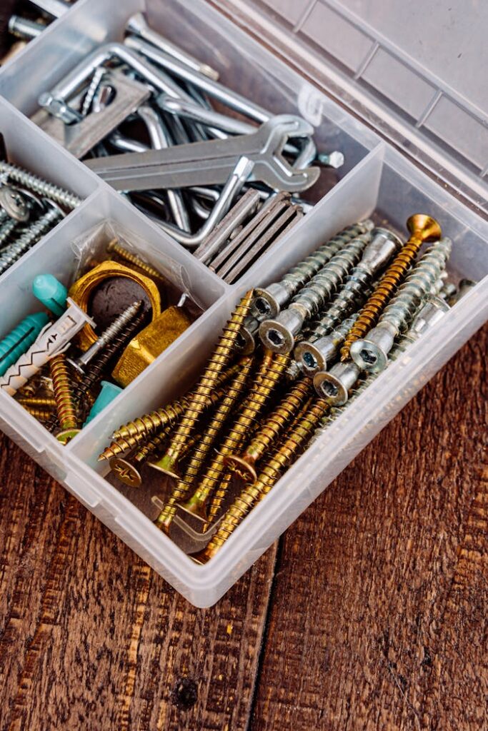pexels-photo-5853930 Close-up view of a toolbox containing assorted screws, wrenches, and tools on a wooden surface.